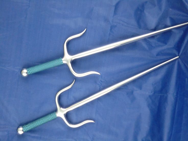 three surgical instruments are laying on a blue sheet, with two handles and one handle