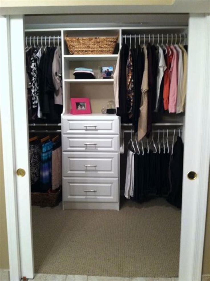 an organized closet with white drawers and clothes