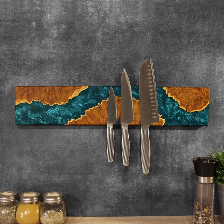 two knives are hanging on the wall next to jars