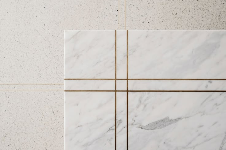 white marble tiles with gold lines on them