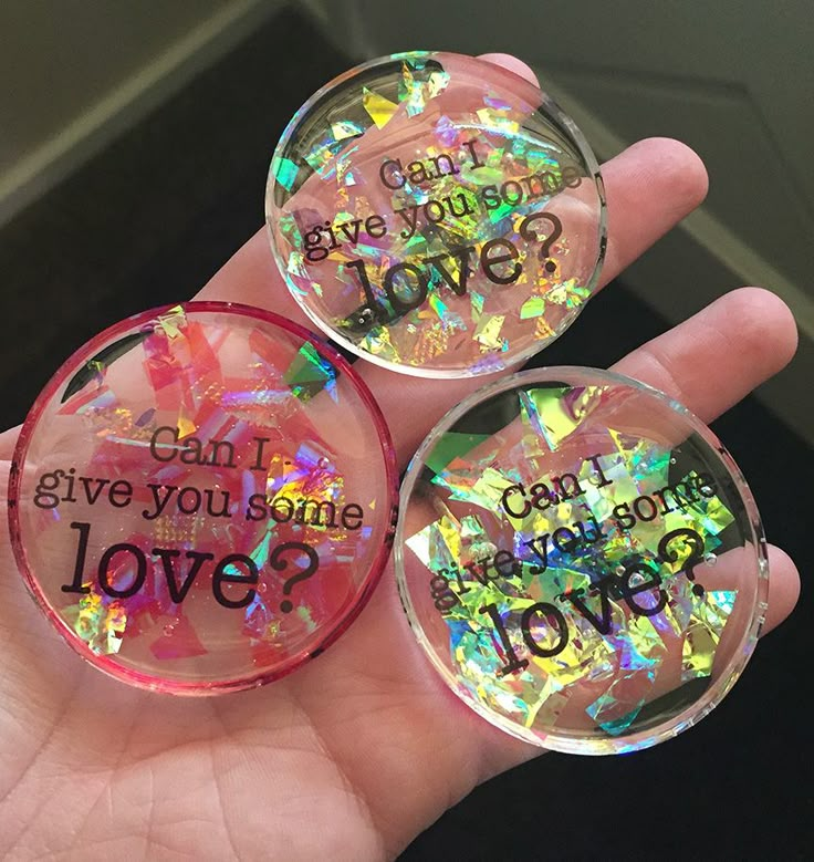 someone is holding three glass magnets that say can you give your love? and can you give you some love?