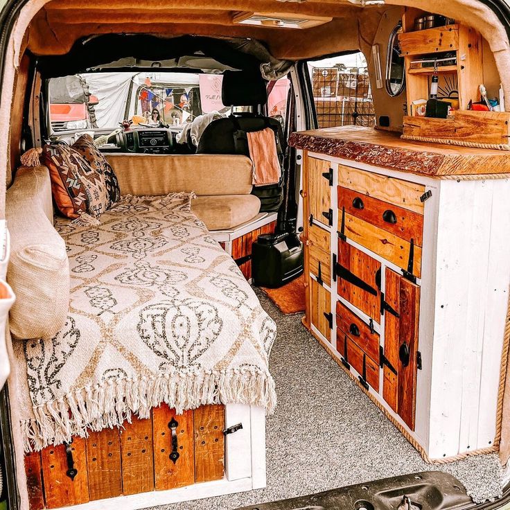 the interior of an old camper van with bed and dressers in it's back