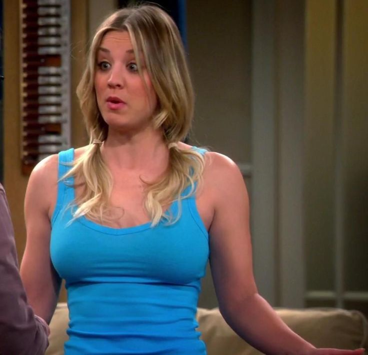 a woman in a blue tank top standing next to a man with his hands out