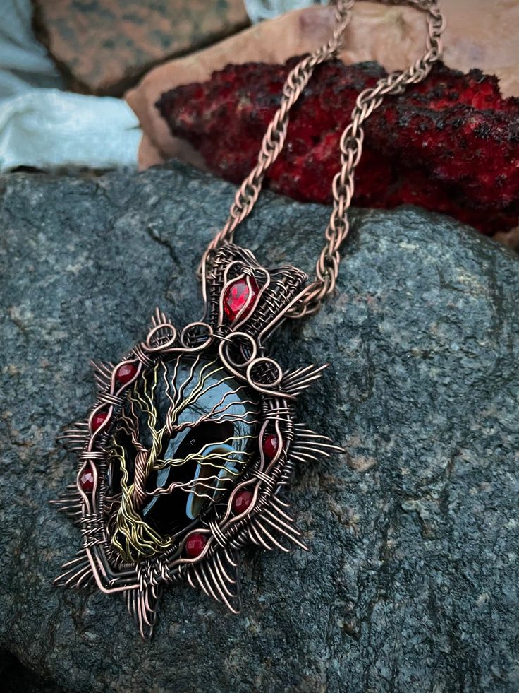 Black Agate tree of life pendant, Tree of life pendant, Wire Wrapped copper pendant Details:  Pendant length:  7 x 4 cm Color: black  This beautiful Tree of Life stone necklace is hand-crafted unisex necklace with black agate and copper wire; Tree of life pendant is hanged on the braided cord or on the copper chain Black Agate is a stone of prosperity, for many years it will take care of the health of its owner. Agates enhance hearing and promote longevity. Black agate amulet transforms negative Unique Tree Of Life Round Pendant Jewelry, Black Round Copper Jewelry, Black Copper Round Jewelry, Unique Black Copper Jewelry, Black Round Pendant Necklace Nature-inspired, Unique Black Oval Pendant Necklace, Tree Of Life Round Pendant Necklace, Unique Tree Of Life Round Pendant Necklace, Black Copper Pendant Necklace