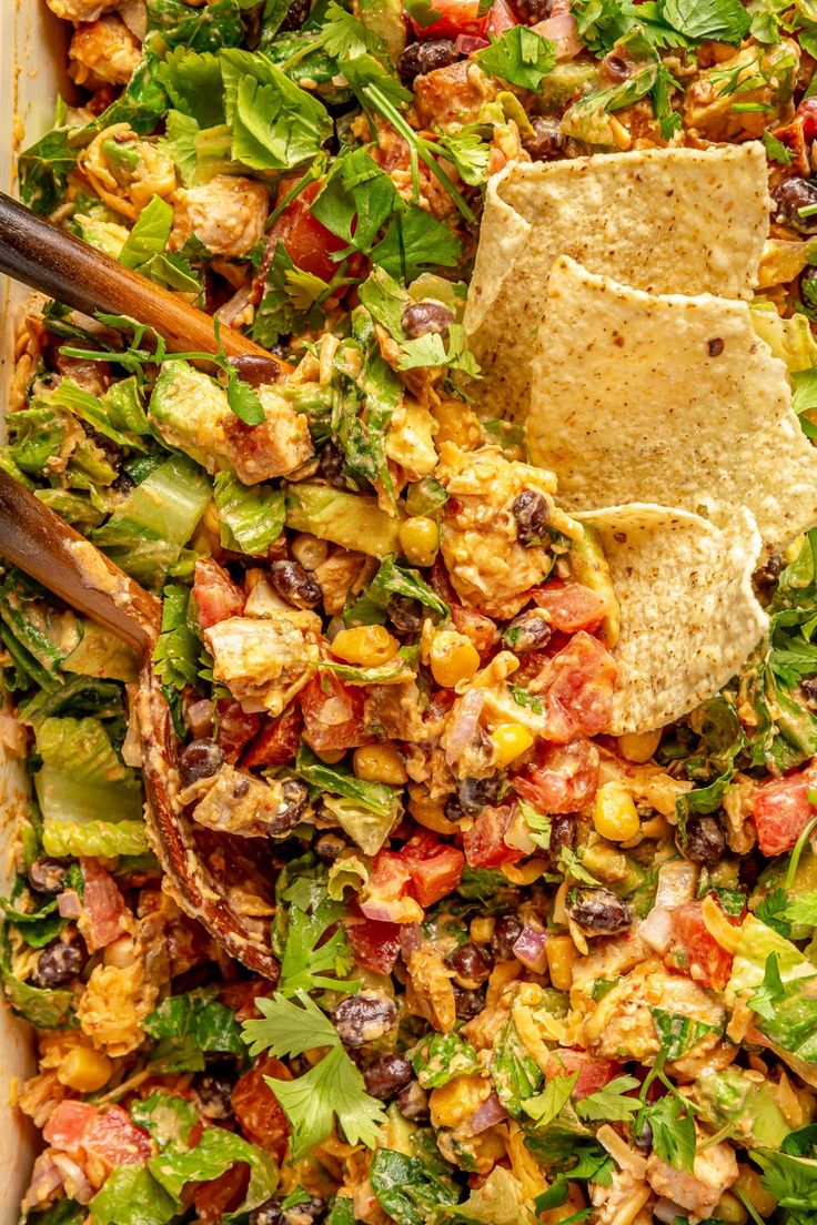 a bowl filled with salad and tortilla chips on top of the dish is ready to be eaten