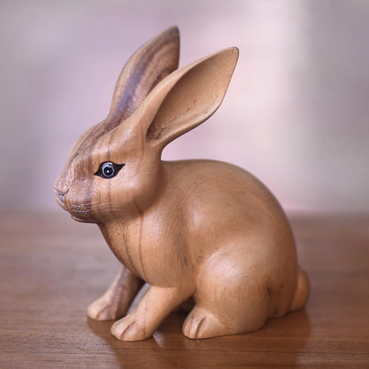 a wooden toy rabbit sitting on top of a table