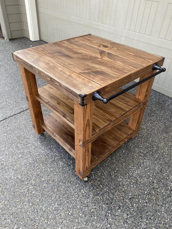 a wooden table sitting on top of a cement floor next to a white garage door