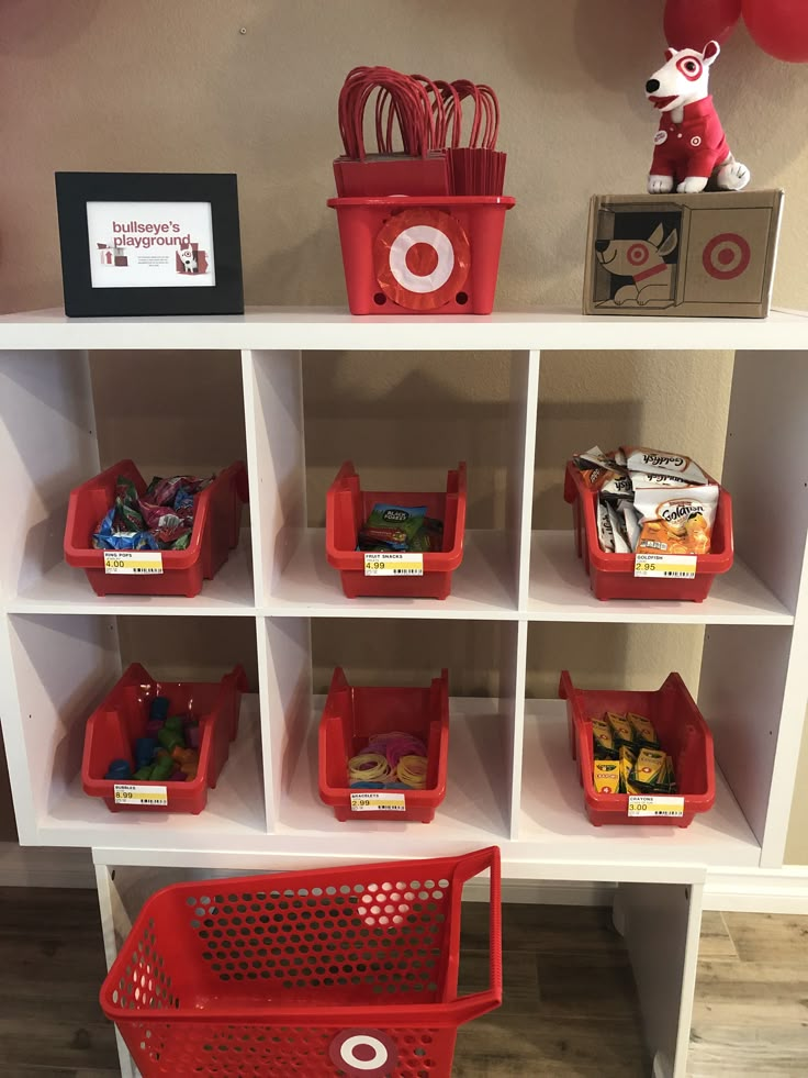 the shelves are filled with red baskets and toys