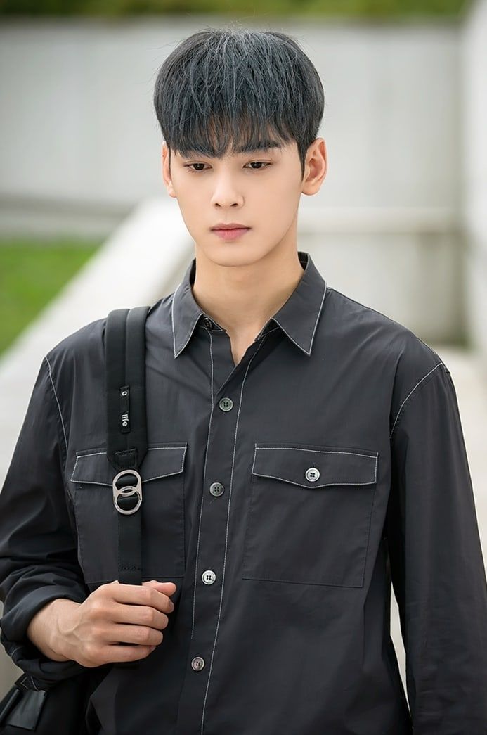 a young man with black hair wearing a black shirt