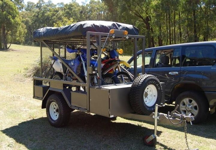 a truck with two bikes on the back of it's bed in a field