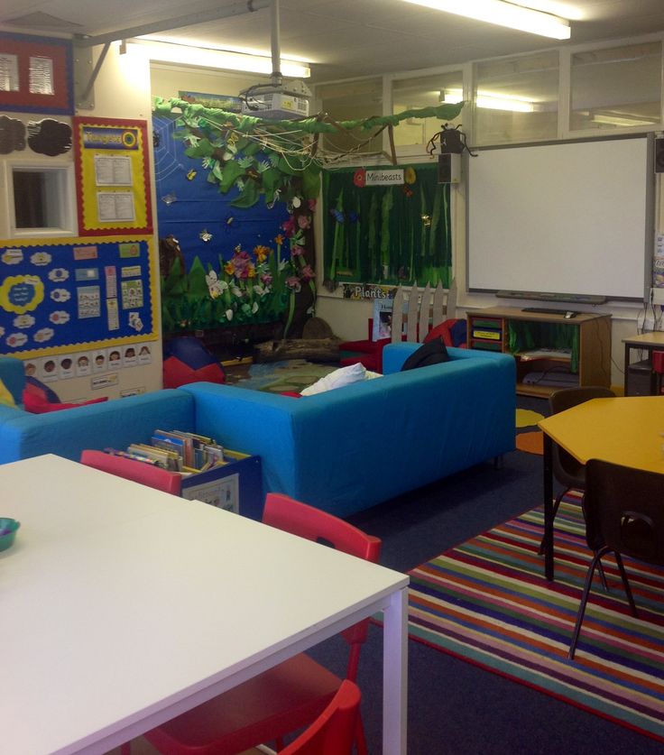 a classroom with blue couches and colorful rugs