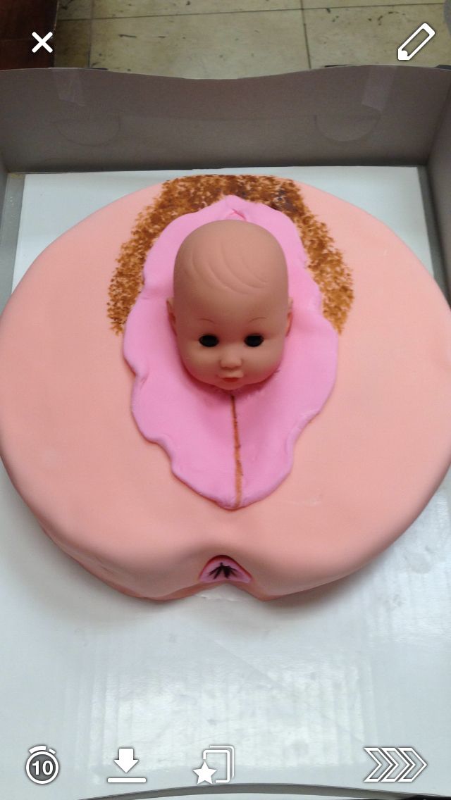 a pink cake with a baby's head on it