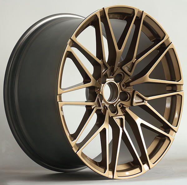 a close up of a wheel on a white background with a black rim and gold spokes