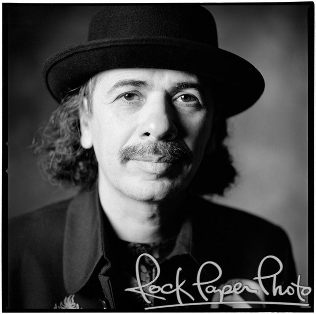 a black and white photo of a man wearing a top hat with long curly hair