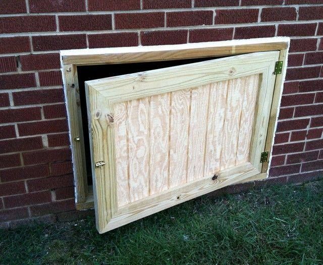 a wooden door is open in front of a brick wall and green grass on the ground