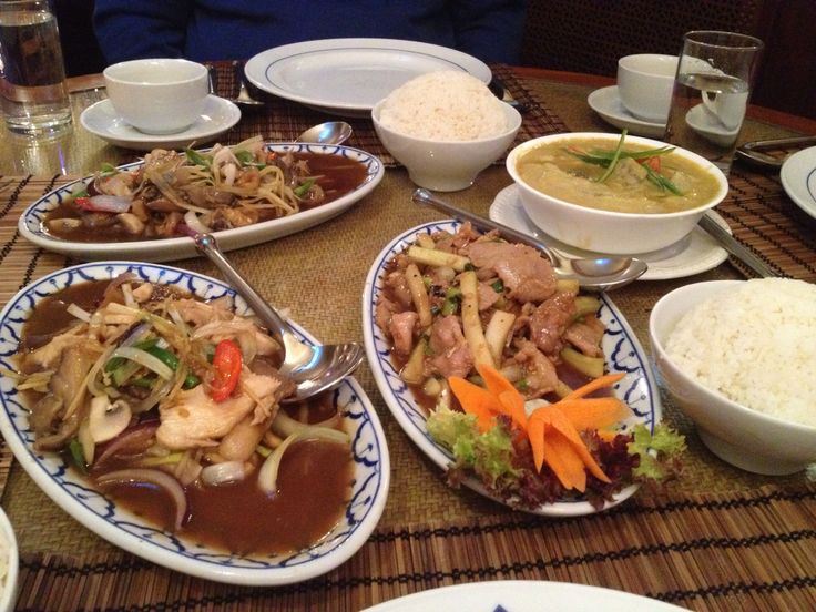 a table topped with plates of food next to bowls of rice and soup on top of a wooden table