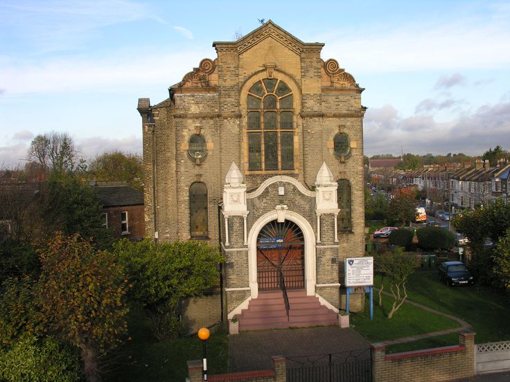 an old church building with a clock tower on the front and side entrance to it