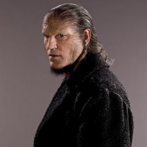 a man with long hair wearing a black coat