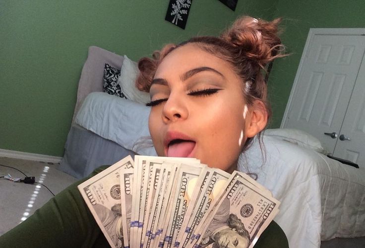 a woman sticking her tongue out while holding money