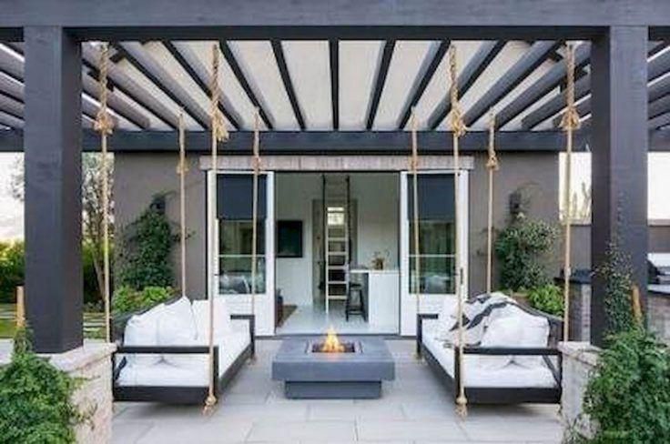 an outdoor living area with swings, couches and fire pit