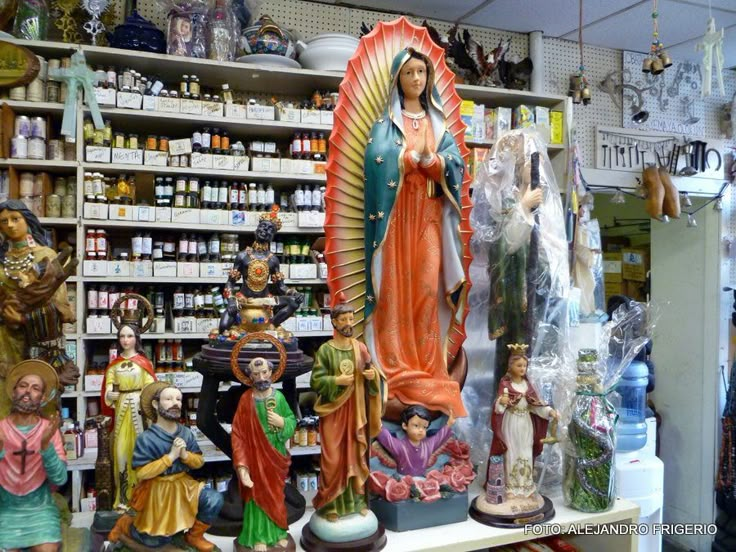 there are many figurines on display in the store, including virgin mary and jesus