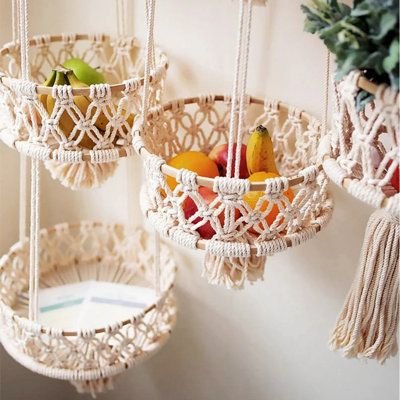 three macrame baskets with fruit in them hanging from the wall