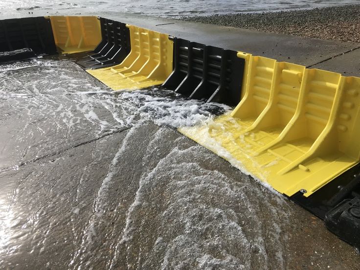 several yellow and black barriers are in the water