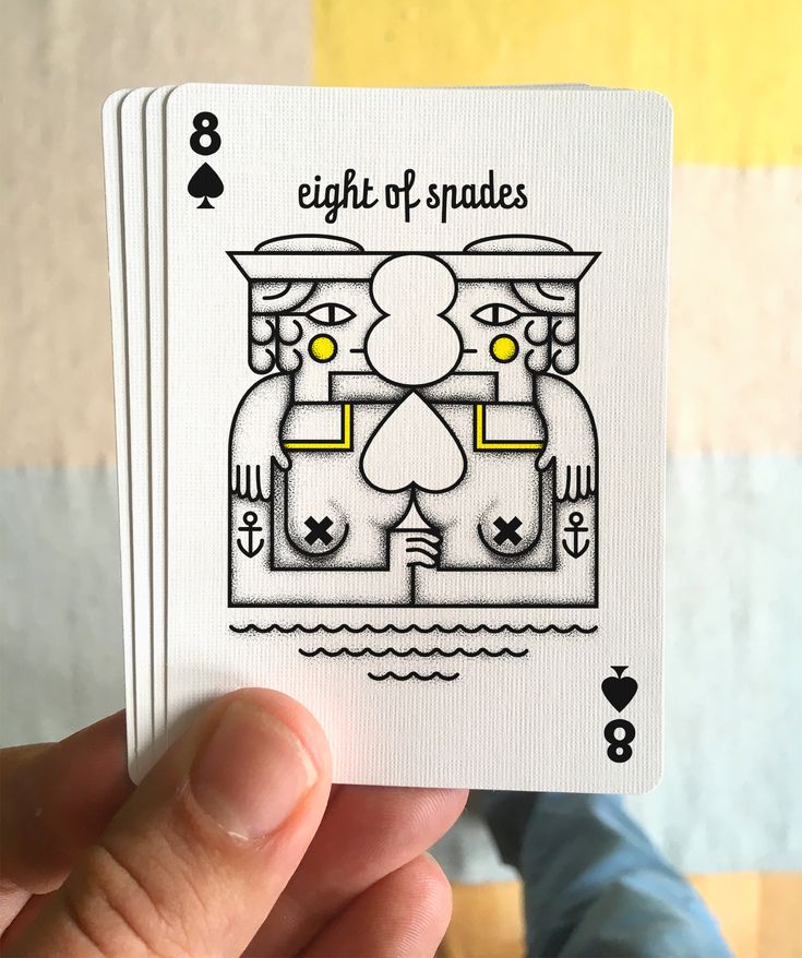 a hand holding up a playing card that says eight of spades