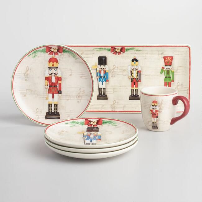 a set of four christmas themed dinnerware with nutcrackers on the side