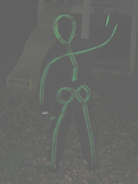 a person standing in the grass with a neon green light