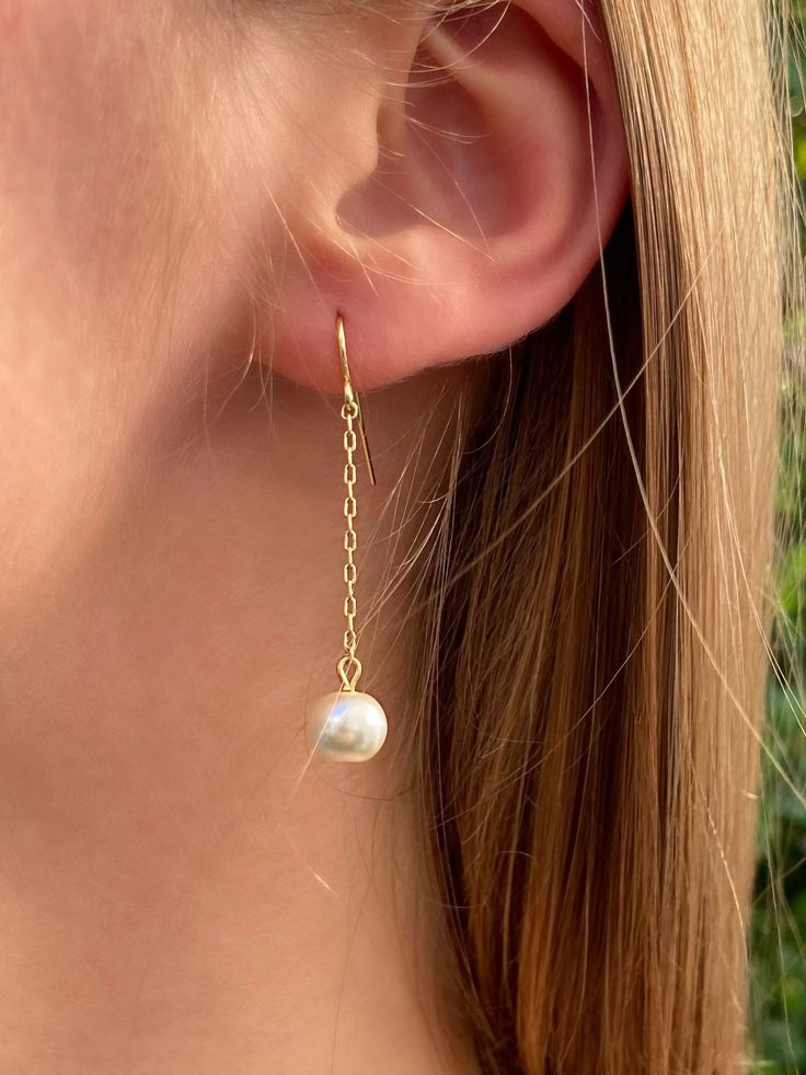 These delicate, handmade, one pearl gold earrings are the ideal gift for anyone who loves beautiful, elegant, and timeless jewelry. Perfect for anniversaries, birthdays, bridesmaids gifts, and more, these earrings pair well with both formal and casual outfits.  Pearls are 8 mm and are available in pink, rose, gray, navy, white, ivory, mint, and caramel colors (see pearl color guide in product photos).  Feature a delicate, gold-plated chain with a drop length of 1.5 in. and a total earring length of 2 (visit my store to see these earrings with silver chain). Pearl Dangle Threader Earrings For Gift, Handmade Elegant Dangle Threader Earrings, Elegant Handmade Long Drop Threader Earrings, Pearl Chain Drop Threader Earrings As Gift, Delicate Pearl Chain Earrings For Gift, Drop Threader Earrings With Pearl Chain For Gift, 14k Gold Filled Pearl Chain Earrings As Gift, Gift Yellow Gold Linear Earrings With Pearl Charm, Yellow Gold Linear Earrings With Pearl Drop For Gift