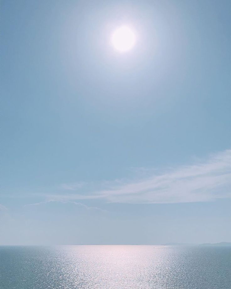 the sun is shining over the ocean on a clear day