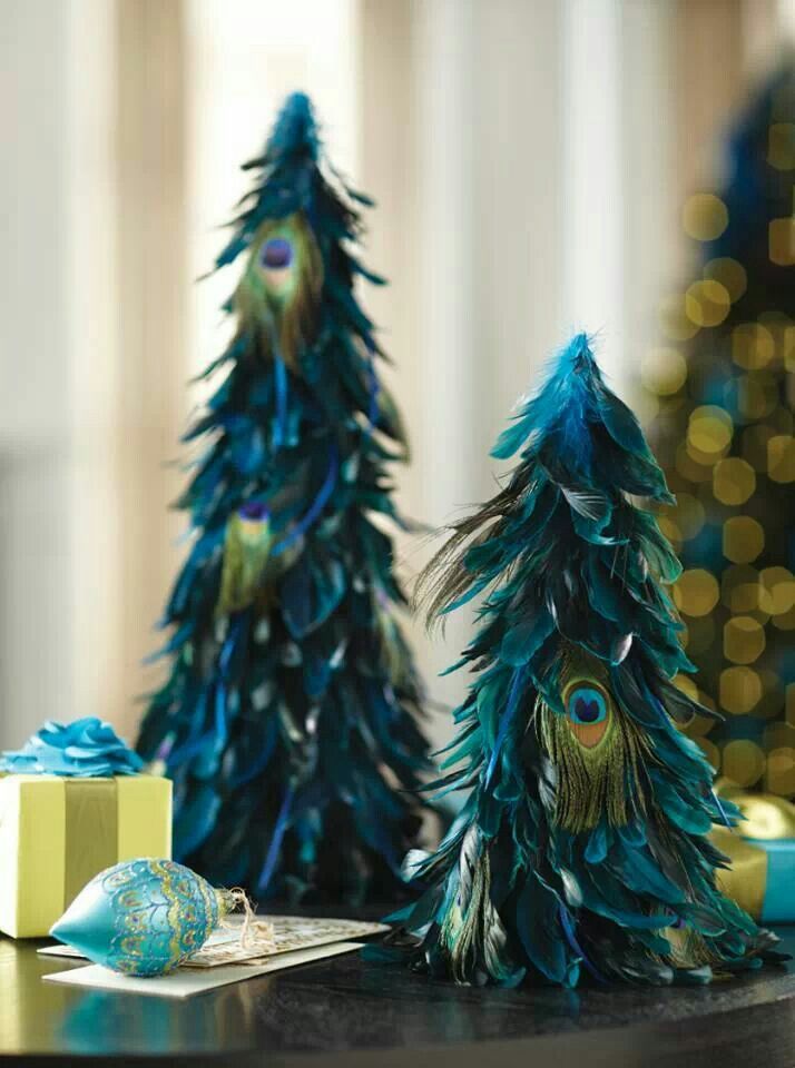 two peacock trees sitting on top of a table next to a present box and christmas tree