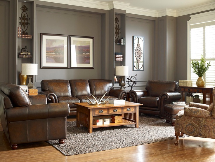 a living room filled with lots of furniture and decor on top of a hard wood floor