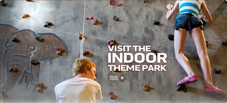 a man and woman climbing up the side of a rock wall