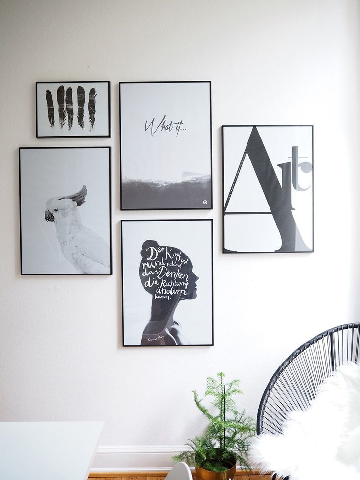 a white room with pictures on the wall and a wicker chair next to it