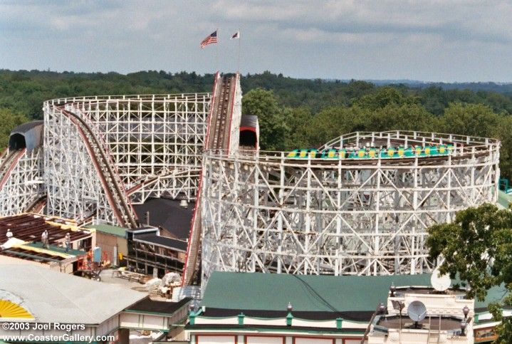 an amusement park with several roller coasters in the background and trees around it,