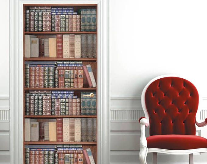 a red chair sitting in front of a book shelf filled with books next to a white wall