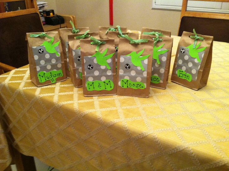 three brown bags with green designs on them are sitting on a yellow tablecloth covered table