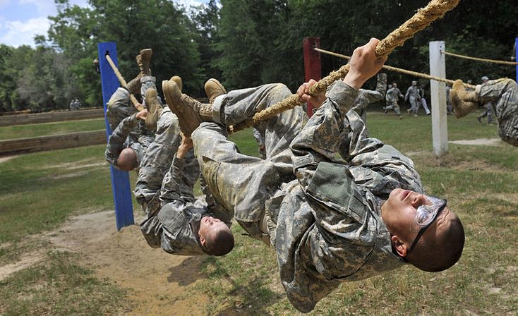 a man hanging upside down in the air with ropes attached to his feet and hands