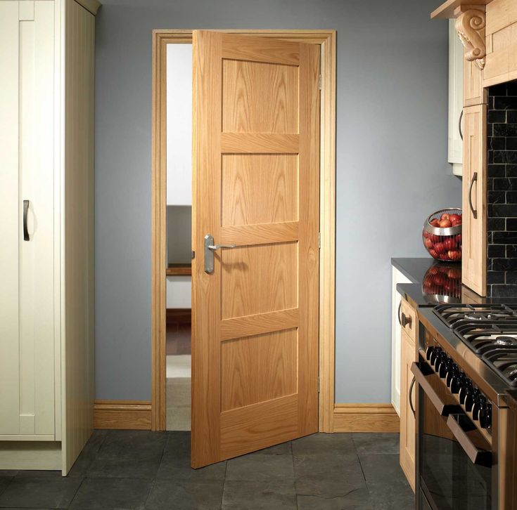 an open door in a kitchen with blue walls and tile flooring, next to a stove top oven