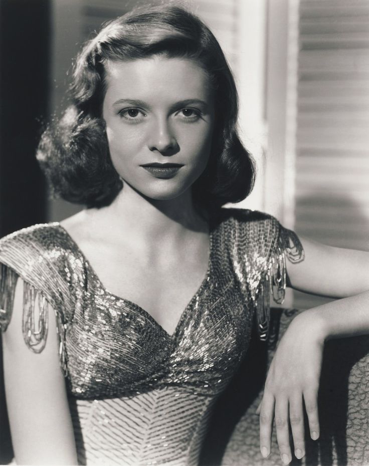 an old black and white photo of a woman wearing a dress with sequins