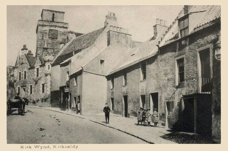 an old black and white photo of people walking down the street in front of buildings