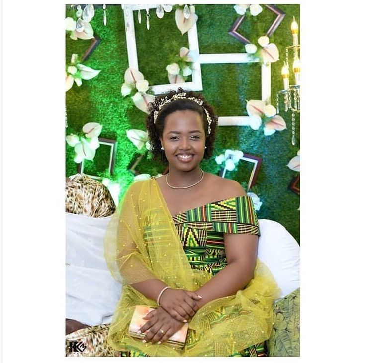 a woman in a yellow dress sitting on a white couch with green wall behind her