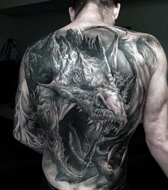 a man with tattoos on his back has a dragon and demon tattoo on his left shoulder