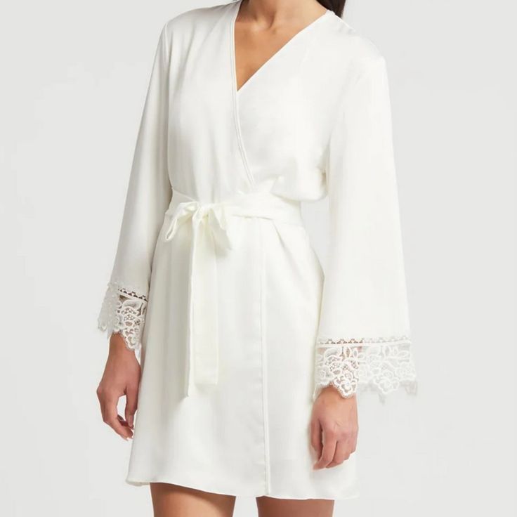 Anthropologie Rya Collection Rosey Cover Up In Ivory Satin. Short Style Robe With Side Pockets. Ties At Waist. Lace Trimmed Sleeves. New With Tag. Underarm To Underarm Measured Flat Across The Back Is 20" And Stretches To 22". Hip To Hip Measured Flat Across The Back Is 24" And Stretches To 26". Length Is 34" Measuring From Neckline To Hem At The Back. 100% Polyester. Smoke Free, Pet Free Home. Chic V-neck Sleepwear For Wedding Night, Elegant Long Sleeve Lace Sleepwear, Elegant White Sleepwear With Delicate Lace, Cream Elegant Sleep Dress, Cream Sleepwear For Spring, Elegant Long Sleeve Cream Sleepwear, Elegant Spring Sleepwear With Lace Trim, Elegant Fitted Cream Sleepwear, Elegant Lace Sleepwear For Spring