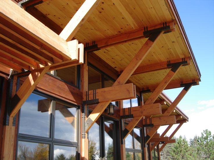 Decorated roofing brackets featuring custom steel details and blond wood, by Phinney Design Group. Roof Brackets, Porch Roof, Steel Detail, Metal Roof, House Ideas, Roof, Porch, Cabin, Exterior