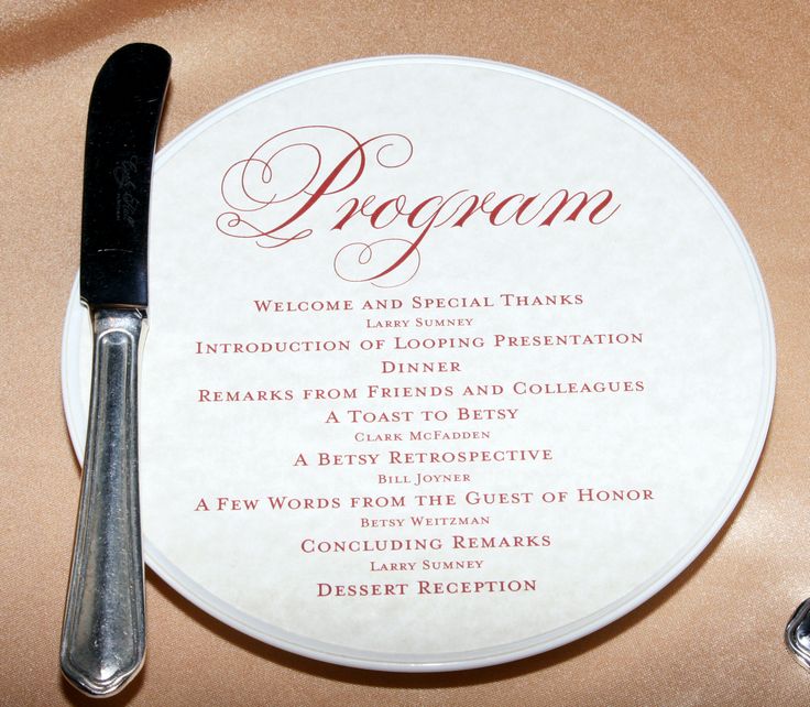 a plate with a knife on top of it next to a fork and menu card