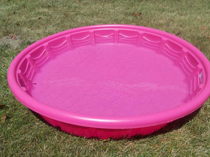 a pink plastic swimming pool in the grass