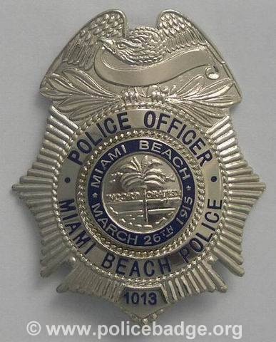 the miami beach police badge is shown on a white background with blue and silver trim